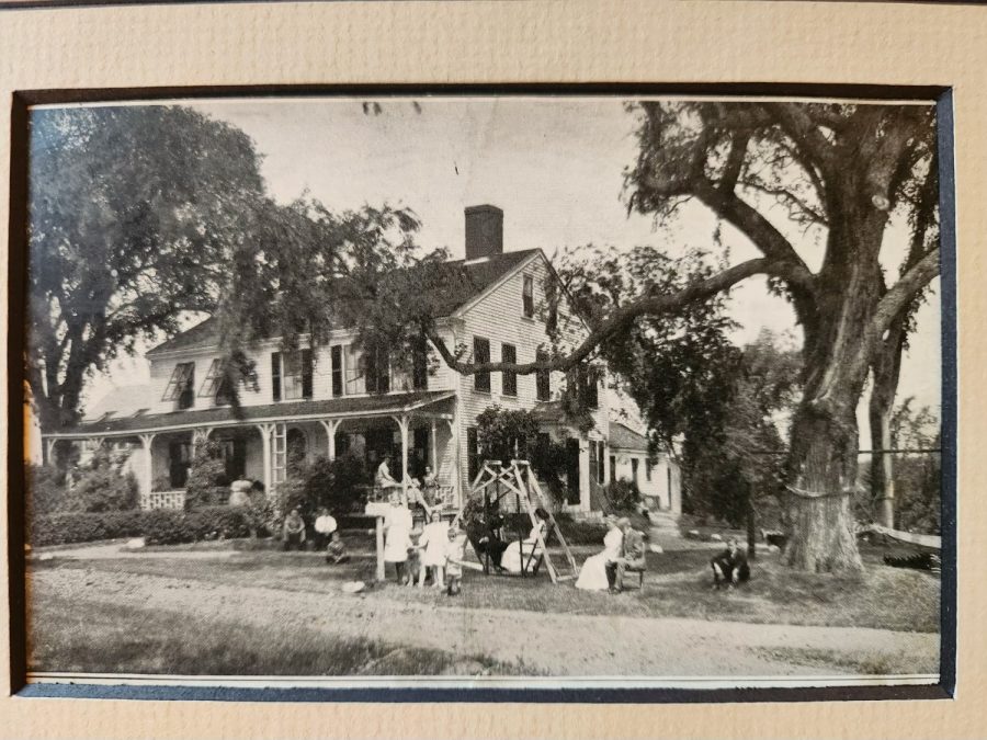Historic photograph with a group of people on the lawn in front of the house