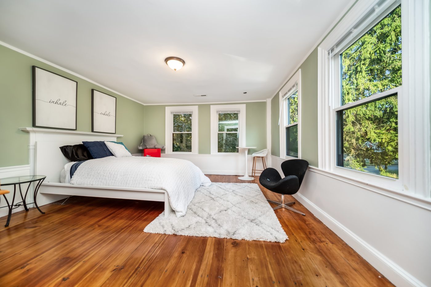 A bright bedroom with windows on two walls