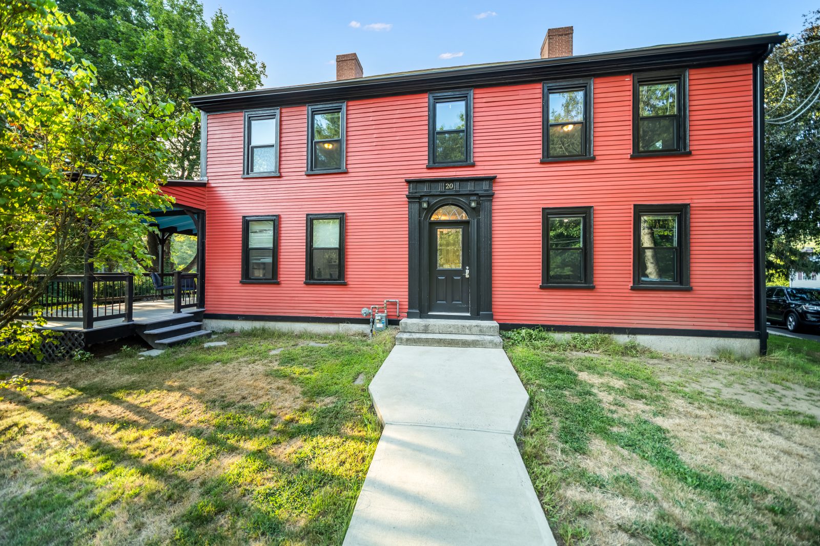 The front elevation of The Elms at 20 Harnden Street, Wilmington, Massachusetts, in red clapboard with black trim and a centre entrance